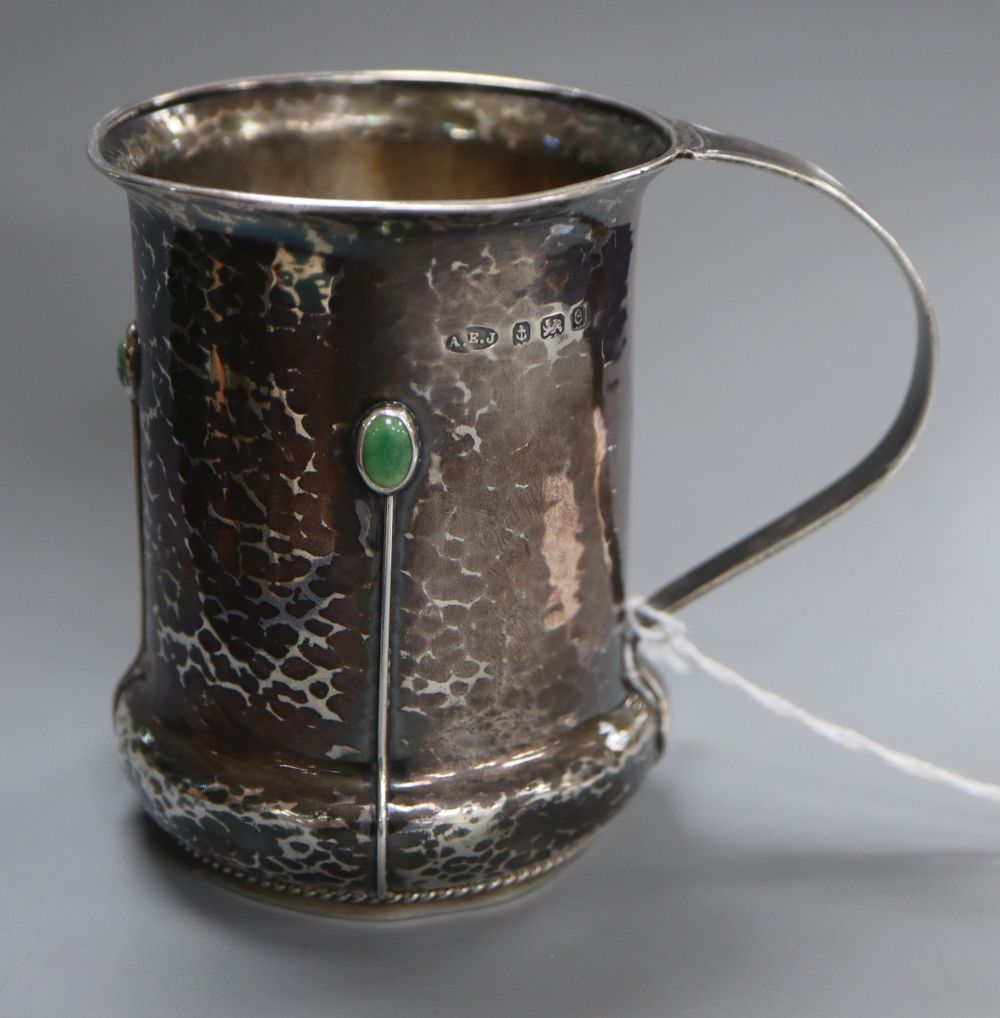 An Edwardian Arts & Crafts silver and turquoise cabochon set mug, by Albert Edward Jones, Birmingham, 1904, 82mm, gross 112 grams.
